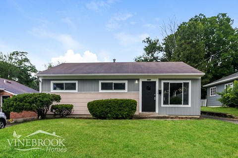 a small bungalow with a lawn in front of it